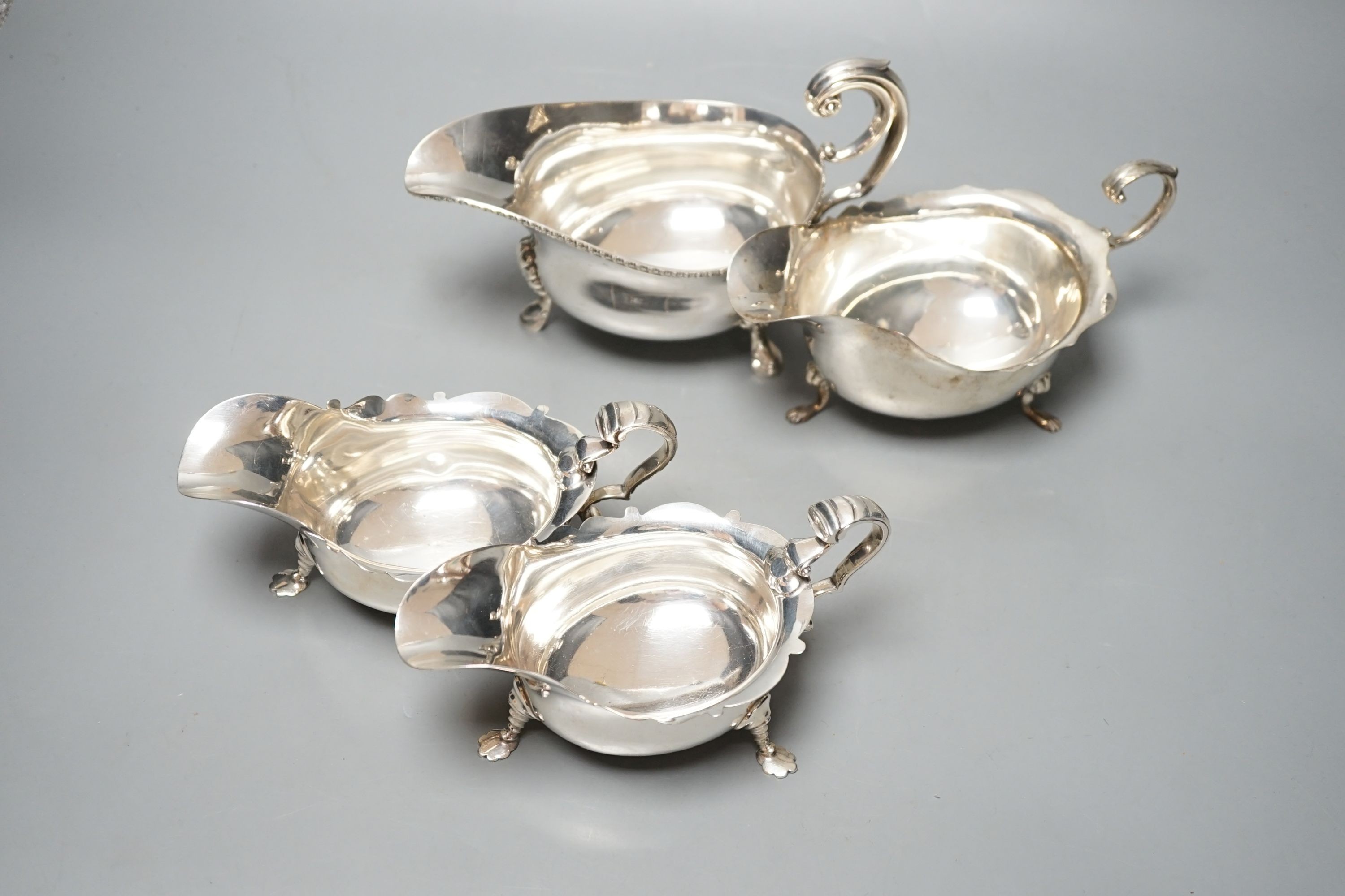 A pair of George V silver sauce boats, London, 1930 and two other larger silver sauceboats, 26oz.
